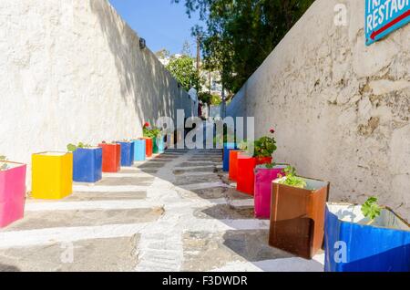 Eine typische griechische Insel gepflasterte Gasse in Chora, Mykonos, Griechenland mit bunte Blumentöpfe von Geranien geschmückt und umgeben von b Stockfoto