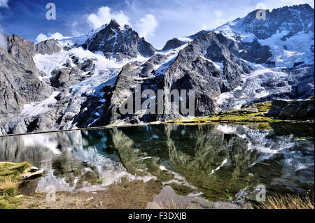 Panoramablick auf die Gletscher von La Meije mit Reflexion in einem künstlichen See auf halbe Höhe, Französische Alpen, Frankreich Stockfoto