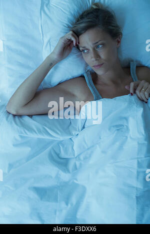 Frau wach im Bett liegend Stockfoto