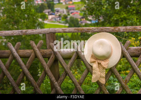 Weibliche Sommerhut hängen rustikale Holzzaun. Kleinen Griff gedreht Stockfoto