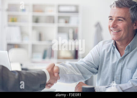 Reifer Mann Händeschütteln mit Geschäftsmann Stockfoto