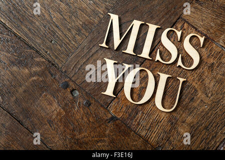 Holzbuchstaben, die Bildung von Wörtern vermisse dich auf alte Vintage Holzplatten mit Platz für Ihren eigenen Text geschrieben. Stockfoto