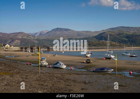 Am späten Nachmittag Sonne leuchtet einen Blick auf Barmouth Hafen mit alten Eisenbahnbrücke und Cader Idris Bergketten in der Ferne. Stockfoto