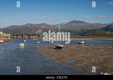 Am späten Nachmittag Sonne leuchtet einen Blick auf Barmouth Hafen mit alten Eisenbahnbrücke und Cader Idris Bergketten in der Ferne. Stockfoto