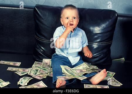 Kleiner Junge mit gefälschtem Geld denken Stockfoto