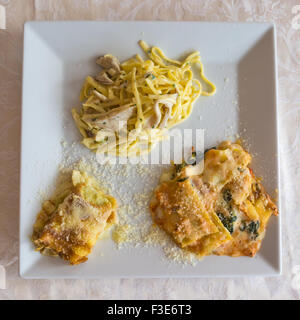 Abgebildeten drei typische italienische Gerichte, Lasagne, Crepes mit Aspagi und Nudeln mit Sahne und Pilzen, serviert in einer weißen Schale. Stockfoto