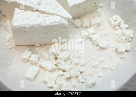 Käseprodukte: Raw weichen mediterranes Feta weiß Käsewürfel und Runde am weißen Stoff in Platte. Stockfoto