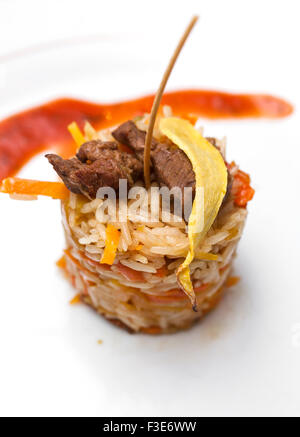 Gebratenes Rindfleisch mit schwarzem Pfeffer und Bratkartoffeln auf Reis Stockfoto