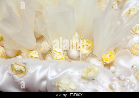 Elegante Hochzeitsbevorzugungen dekoriert mit künstlichen Blumen Stockfoto