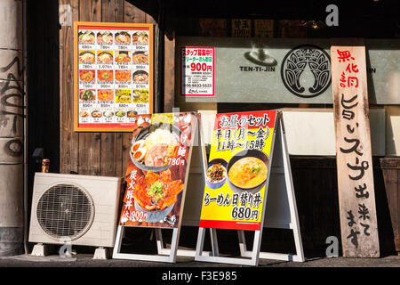 Japan, Osaka. Menü Anzeige Bretter auf Bürgersteig außerhalb Nudelbar. Zwei Bretter, und Hauptmenü auf Wand mit Fotos von allen Gerichten. Klimaanlage. Stockfoto