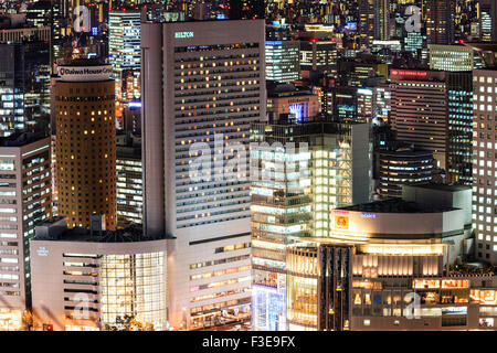 Japanische Stadt, Osaka, Abendlicher Blick von der Umeda Sky Building, Bürogebäuden und Hotels, einschließlich der Finanzierungsmöglichkeiten durch den Hilton Gebäude. Beleuchtet, nachts. Stockfoto