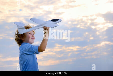 Junge werfen Flugzeug im Bereich Stockfoto