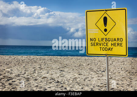 Keine Rettungsschwimmer Schild am Bronte Beach, Bronte, Sydney, Australien mit Schwimmer im Hintergrund. Stockfoto