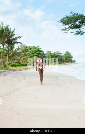 Eine Afro-brasilianische Frau Wandern entlang dem Strand auf der Insel Itaparica, Bahia Stockfoto