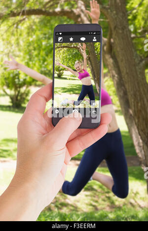 Zusammengesetztes Bild von weiblicher Hand, die eine smartphone Stockfoto