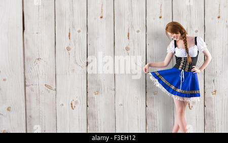 Zusammengesetztes Bild des Oktoberfest Mädchen ihren Rock zu verbreiten Stockfoto