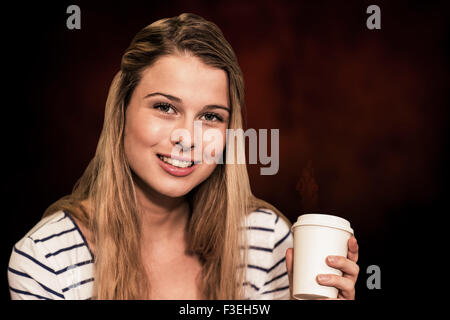 Zusammengesetztes Bild Porträt des Lächelns Studentin Holding Einweg-Kaffeetasse