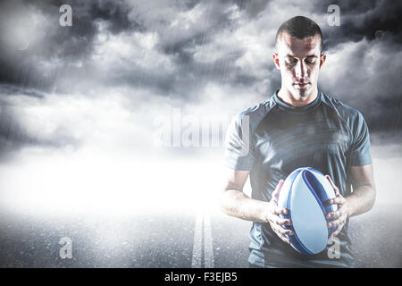 Zusammengesetztes Bild des nachdenklichen Rugby-Spieler mit ball Stockfoto