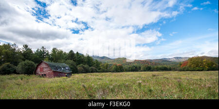 Alte laufen Scheune mit Herbstfarben in den Adirondacks im Hintergrund Stockfoto