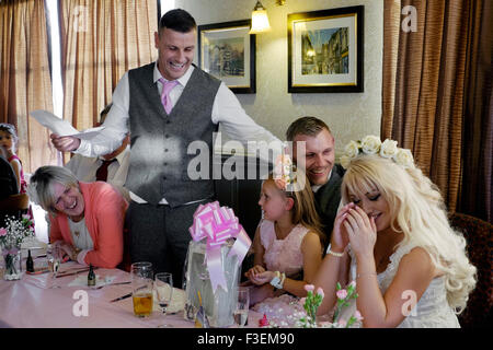 der Bräutigam lacht Braut nämlich in den besten mans Rede bei einer Hochzeit Empfang England uk Stockfoto
