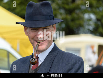 Ein Mann, der in 1940er-Jahren-Kleidung gekleidet war und eine Pfeife rauchte, bei einer Show aus den 40er-Jahren in großbritannien Stockfoto