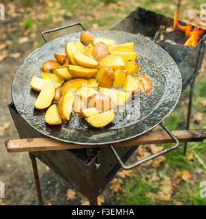 Gebratene Kartoffel in großen melal Pot. Auf Grill und offenem Feuer, Rauch. Stockfoto