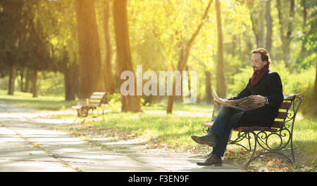 Mann liest Newpaper im park Stockfoto