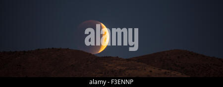 Seltene totale Mondfinsternis Super Vollmond. Halbe Eclipse steigt über die Berge, Boise, Idaho, USA Stockfoto