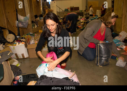 Freiwillige in einer Reederei Lager packen gespendet, Kleidungsstücke und andere nicht verderbliche Güter für den Versand nach Stockfoto
