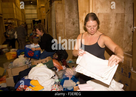 Volunteer in einem Umzugsunternehmen Lager packen gespendet, Kleidungsstücke und andere nicht verderbliche Güter für den Versand in G Stockfoto