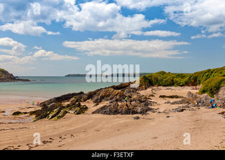 Besucher genießen den Sonnenschein an einem Strand in West Angle Bay in Pembrokeshire Coast National Park, Wales, Großbritannien Stockfoto