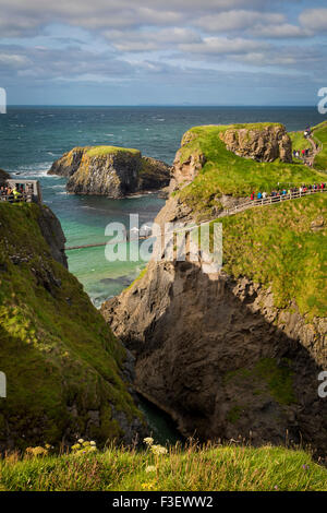 Touristen Fuß über die Carrick-a-Rede Rope Bridge entlang der nördlichen Küste, County Antrim, Nordirland, Vereinigtes Königreich Stockfoto