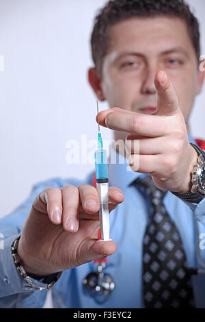 Arzt eine Spritze mit Impfstoff vorbereiten, indem sie darauf tippen, um die Luftblasen zu entfernen Stockfoto