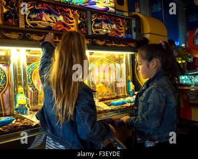 Zwei junge Mädchen spielen einen Spielautomaten in einer Spielhalle Penny. Stockfoto