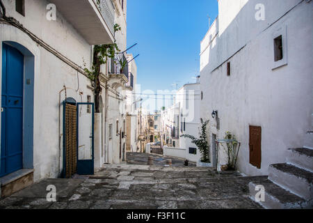 Engen kopfsteingepflasterten Gasse zwischen weiß gewaschen mediterrane Häuser am Hang in Ibiza, Spanien an sonnigen Tag mit blauem Himmel Stockfoto