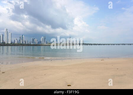 Sandstrand mit der neuen Autobahn über die Bucht und die Wolkenkratzer von Panama-Stadt im Hintergrund, Panama, Mittelamerika Stockfoto