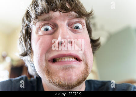 Ein junger Mann der kaukasischen in seiner Mitte der 20er Jahre macht ein lustiges Gesicht mit weit aufgerissenen Augen. Closeup. USA. Stockfoto