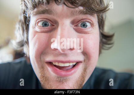 Ein lustiges Gesicht macht einen jungen kaukasischen Mann in seiner Mitte der 20er Jahre. Closeup. USA. Stockfoto