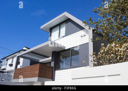 Modernen grauen und weißen Haus mit blauen Himmel und Holzbalkon und Bäume Stockfoto