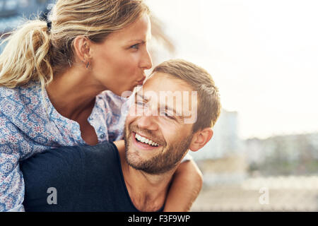 Frau Mann küssen, während er lacht, junges Paar Stockfoto