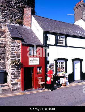 Das kleinste Haus in Großbritannien mit einer walisischen Dame in Tracht im Vordergrund, Conwy (Conway), Gwynedd, Wales. Stockfoto