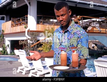 Hotel Kellner hielt ein Tablett mit Cocktails in der Grafton Beach Resort, Stonehaven Bay, Tobago. Stockfoto