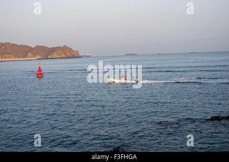 Angelboot/Fischerboot im Hafen von Muscat in das Sultanat Oman mit Bergen im Hintergrund und eine rote Boje Stockfoto