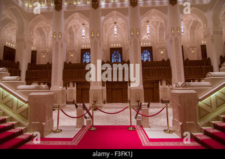 Lobby und Treppe mit hohen Bögen und eine reich verzierte Holzdecke im Royal Opera House in Shati Al-Qurm, Muscat, Oman Stockfoto