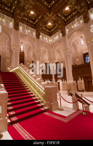 Lobby und Treppe mit hohen Bögen und eine reich verzierte Holzdecke im Royal Opera House in Shati Al-Qurm, Muscat, Oman Stockfoto