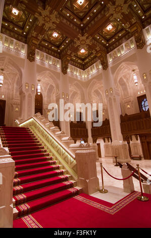 Lobby und Treppe mit hohen Bögen und eine reich verzierte Holzdecke im Royal Opera House in Shati Al-Qurm, Muscat, Oman Stockfoto