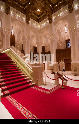 Lobby und Treppe mit hohen Bögen und eine reich verzierte Holzdecke im Royal Opera House in Shati Al-Qurm, Muscat, Oman Stockfoto