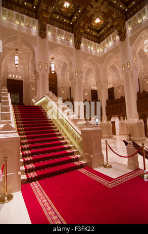 Lobby und Treppe mit hohen Bögen und eine reich verzierte Holzdecke im Royal Opera House in Shati Al-Qurm, Muscat, Oman Stockfoto