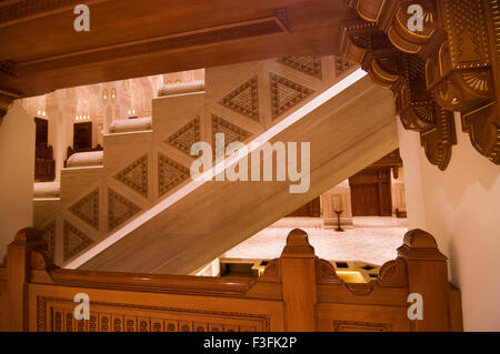 Lobby und Treppe mit hohen Bögen und eine reich verzierte Holzdecke im Royal Opera House in Shati Al-Qurm, Muscat, Oman Stockfoto