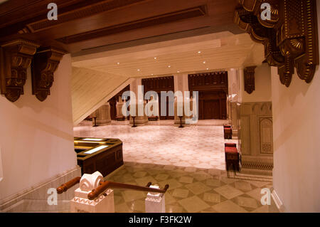 Lobby und Treppe mit hohen Bögen und eine reich verzierte Holzdecke im Royal Opera House in Shati Al-Qurm, Muscat, Oman Stockfoto